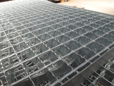 Metal Grating Surface::Close-up of a galvanized metal grating surface showing its grid pattern and texture.
