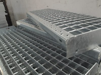 Stacked galvanized metal grating platforms showcasing a grid pattern, used for heavy-duty flooring or shelving applications.